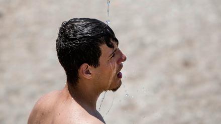 Ein wenig Abkühlung sucht dieser Mann an einem Strand bei Athen.
