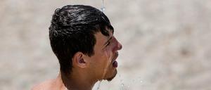 Ein wenig Abkühlung sucht dieser Mann an einem Strand bei Athen.