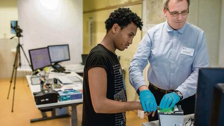 Die Fingerabdrücke des Flüchtlings Filimon, der nach eigenen Angaben aus Eritrea kommt, werden in der Erstaufnahmestelle in Suhl (Thüringen) von Sachbearbeiter Jörg Kenschik mit einem Scanner registriert.