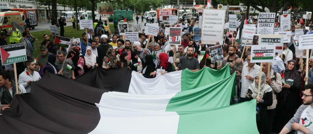 Demonstranten tragen bei der anti-israelischen Demonstration anlässlich des Al-Quds-Tages in Berlin die Flagge Palästinas.