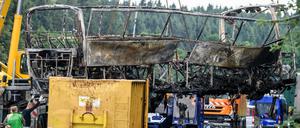 Das Wrack eines nach einer Kollision mit einem Lkw völlig ausgebrannten Reisebusses wird an der Unglücksstelle auf der Autobahn 9 bei Münchberg geborgen.