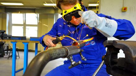 Zum Schutz vor den rumfliegenden Funken trägt der Auszubildende eine Schweißerbrille, die zusätzlich verdunkelt werden kann.