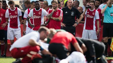 Schockierte Mitspieler schauen zu, während Abdelhak Nouri behandelt wird.