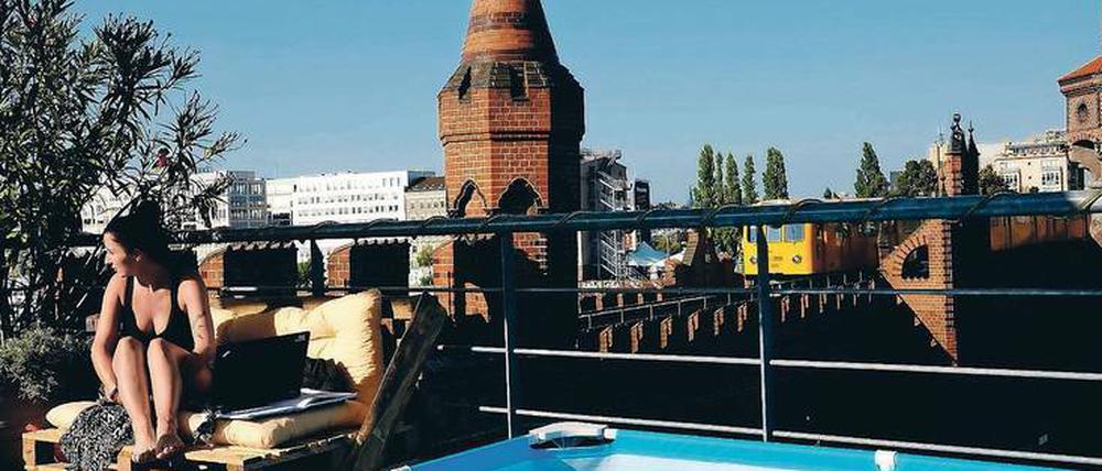 Oleander, Pool und U-Bahn. So lässt sich's leben und arbeiten auf dem Paletten-Sofa im Dachgarten an der Oberbaumbrücke.