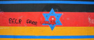 Die einzelnen von Künstlern aus der ganzen Welt bemalten Mauerstücke der East Side Gallery in Berlin - mit aufgesprühtem PFLP-Grafitti. 