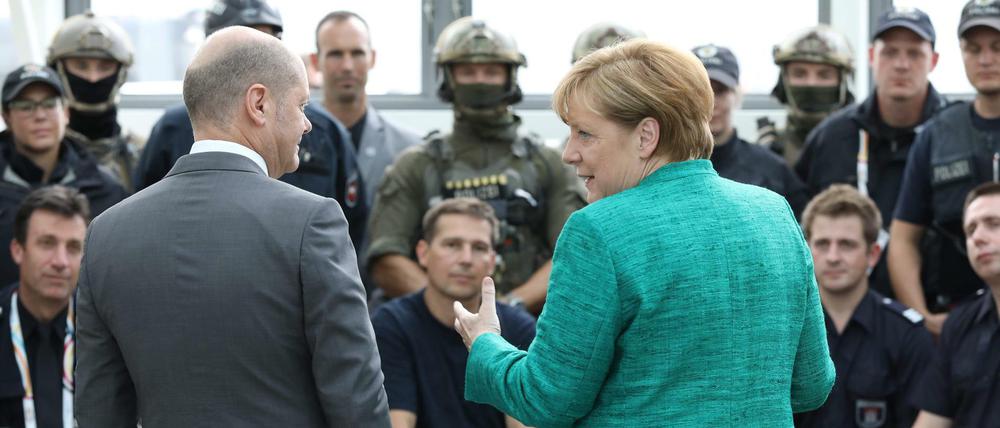 Olaf Scholz und Angela Merkel am Samstag im Gespräch mit Einsatzkräften des Gipfeltreffens.