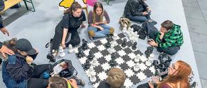 Locker im wahren Leben. Junge Messegäste spielen Mega-Schach am Boden. Drumherum werben zahlreiche Aussteller und Initiativen um das Interesse der jungen Besucher.