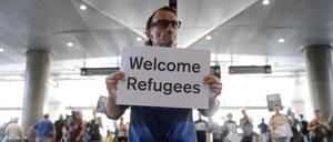 John Wiver demonstriert auf dem Internationalen Flughafen in Long Beach, Kalifornien, (USA) gegen Trumps Einreisesperren mit dem Schild "Flüchtlinge willkommen".