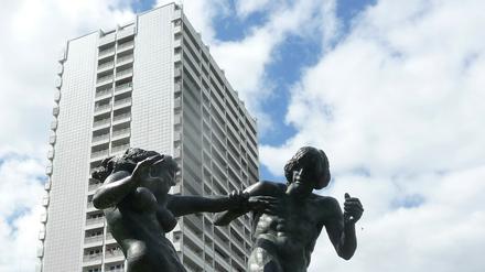 Skulptur "Junges Paar" von Jürgen Raue, aufgestellt 1987 im Fennpfuhlpark. Vorn im Bild Grün, hinten Plattenbau.
