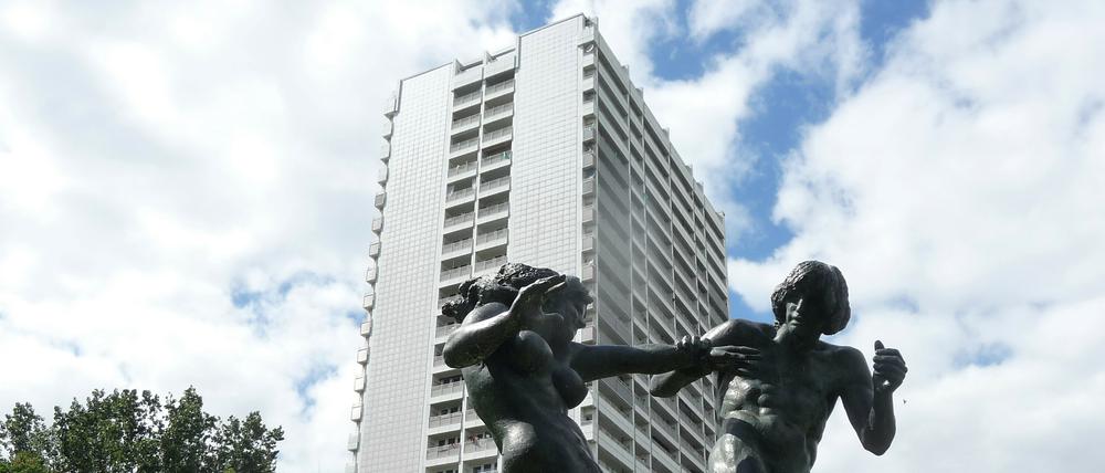 Skulptur "Junges Paar" von Jürgen Raue, aufgestellt 1987 im Fennpfuhlpark. Vorn im Bild Grün, hinten Plattenbau.