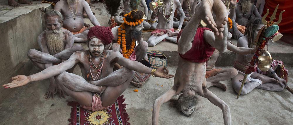 In Gauhati (Indien) praktizieren Sadhus ("heilige Männer") Yoga fast nackt. In Berlin tragen Männer lieber Shorts und T-Shirt. 