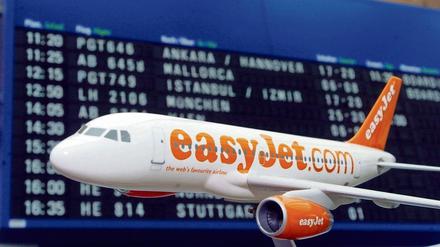 Ein Flugzeugmodell der britischen Billig-Airline easyJet steht vor der Anzeigetafel.