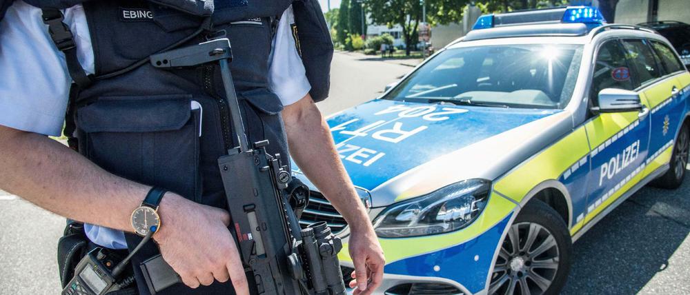 Ein Polizist steht mit seiner Waffe am Montag in Esslingen.