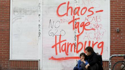 Eine Mutter sitzt mit ihrem Kind am 08.07.2017 in Hamburg im Schanzenviertel nach Ausschreitungen in der Nacht davor wegen des G20-Gipfels.