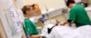 Medizinisches Personal versorgt in einem Krankenhaus einen Patienten.