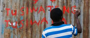 Zeichen gegen Ausgrenzung. "Lasst sie uns nicht vertreiben, lasst sie uns nicht diskriminieren", schreibt der junge Mann in Suaheli auf eine Wand im Kibera-Slum der kenianischen Hauptstadt Nairobi.