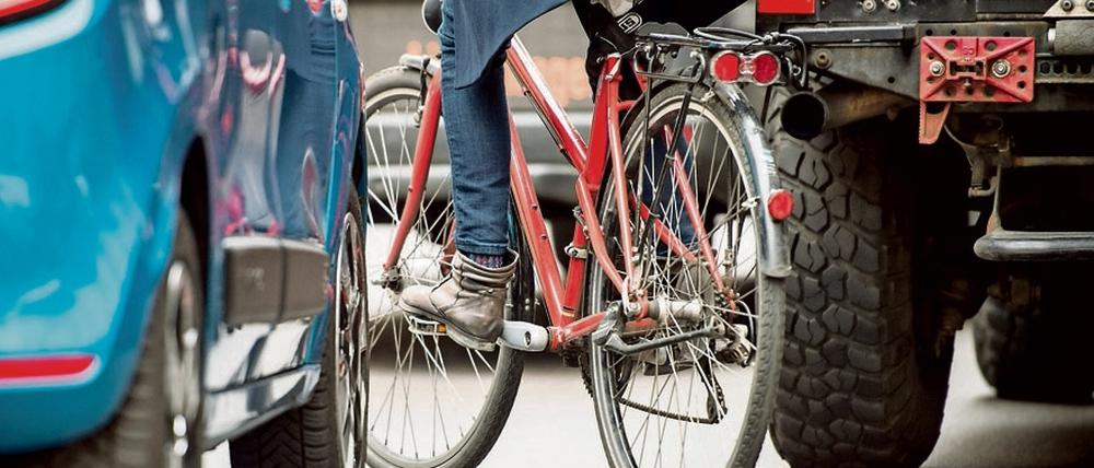 Durch einen zugeparkten Radweg weicht eine Fahrradfahrerin in Berlin auf die Fahrbahn aus.