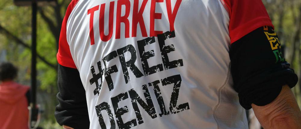 Vor der türkischen Botschaft in Berlin fordert ein Demonstrant die Freilassung des Journalisten Deniz Yücel.