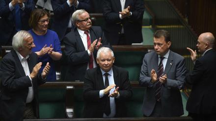 Abgeordnete um den Chef der Regierungspartei PiS, Jaroslaw Kaczynski (Mitte), applaudieren.