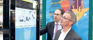Brandenburgs Wirtschaftsminister Albrecht Gerber (rechts, SPD) lässt sich in der Fabrik des Außenwerbers Wall von Geschäftsführer Patrick Möller eine digitale Anzeige erklären.