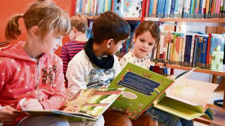 Kinder lesen in der Bibliothek Bücher. 