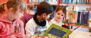 Kinder lesen in der Bibliothek Bücher. 