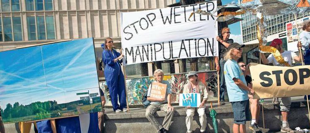 Weltformel des Übels. Wie viel Neues der Verschwörungstheoretiker auch erfahren mag, sein Wissensstand bleibt immer der gleiche. – Das Foto zeigt Demonstranten in Berlin, die gegen die vermeintliche Manipulation des Wetters durch Kondensstreifen von Flugzeugen protestieren. 