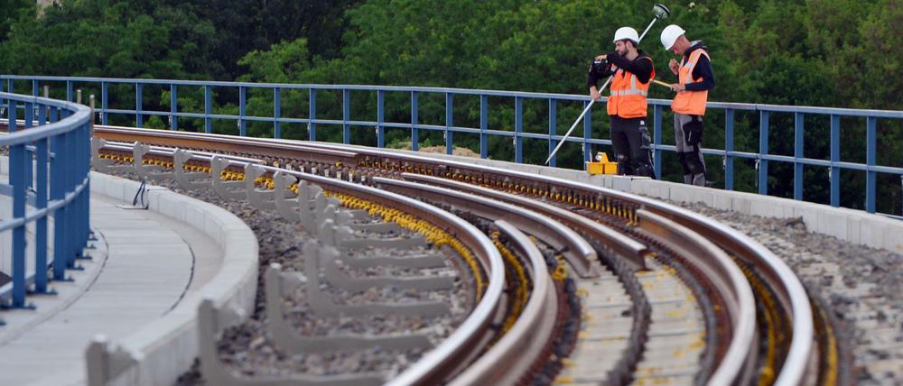 Bauarbeiter stehen am 13.06.2017 in Berlin auf der Baustelle am Bahnhof Ostkreuz an der neuen Brücke neben dem Gleis.