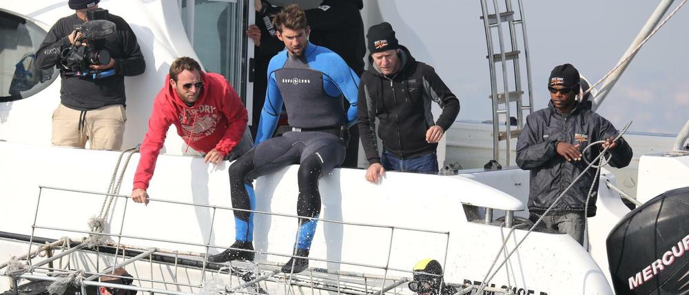 Der ehemalige US-Schwimmstar Michael Phelps (Mitte) sitzt auf einer undatierten Aufnahme vor den Inseln der Bahamas auf dem Boot und bereitet sich auf ein Showrennen gegen einen Weißen Hai vor. Tatsächlich schwamm Phelps dann gegen eine Computeranimation.