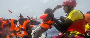 Ein Mitarbeiter der spanischen NGO «Proactiva Open Arms» hebt am 25.07.2017 vor der libyschen Küste ein Kind vom einem Flüchtlingsboot. 