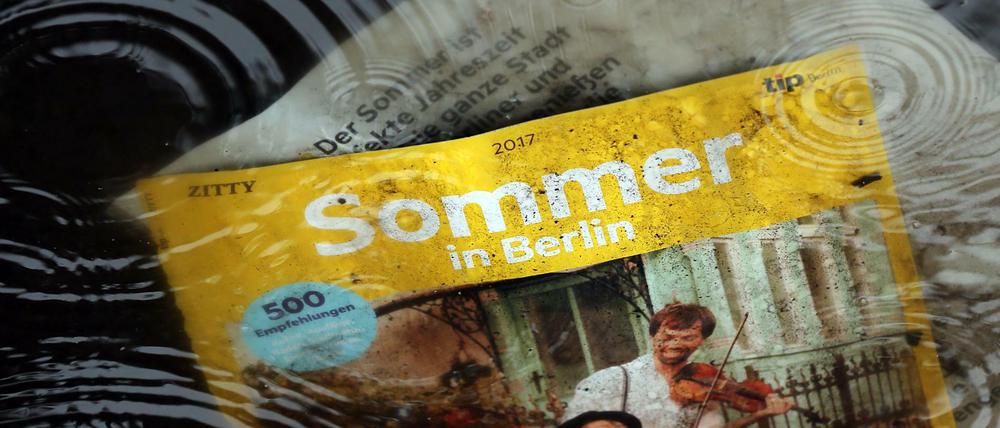 Eine Zeitschrift liegt in einer Regenpfütze. 