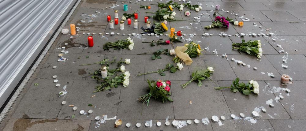 Blumen und Kerzen liegen in Hamburg in einem Peace-Zeichen auf dem Bürgersteig vor dem Supermarkt, in dem am 28.07.2017 ein Mann einen Menschen mit einem Messer getötet und sechs weitere verletzt hat.