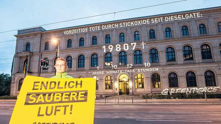 "Endlich saubere Luft" steht am Montag in Berlin auf dem Transparent einer Greenpeace-Aktivistin vor dem Bundesverkehrsministerium.