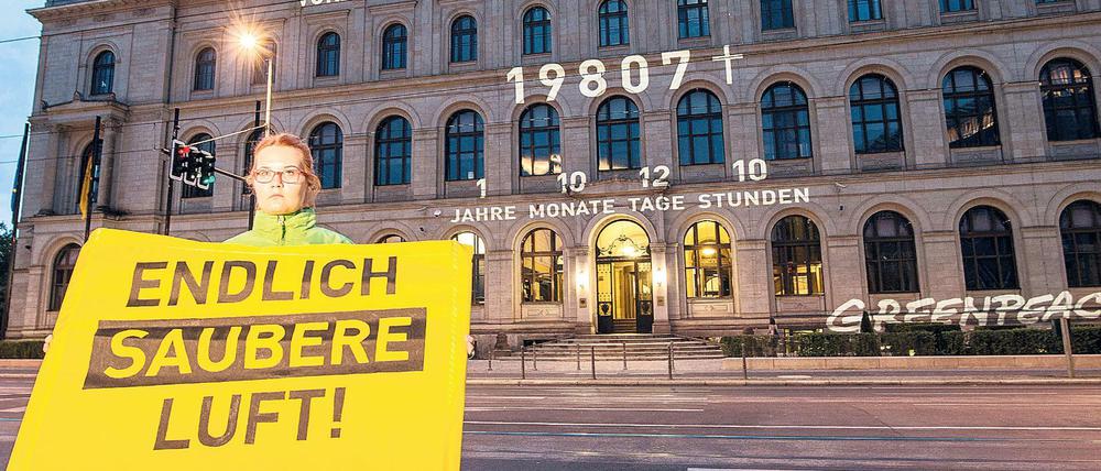 "Endlich saubere Luft" steht am Montag in Berlin auf dem Transparent einer Greenpeace-Aktivistin vor dem Bundesverkehrsministerium.