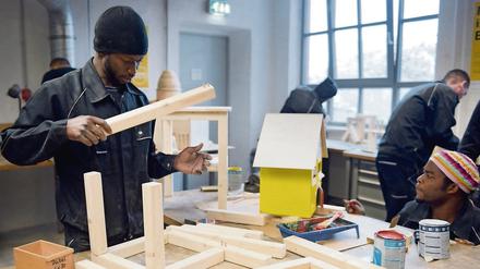 Ein junger Mann arbeitet in der Schreinerei der Flüchtlings-Initiative "Arrivo" der Handwerkskammer Berlin. 