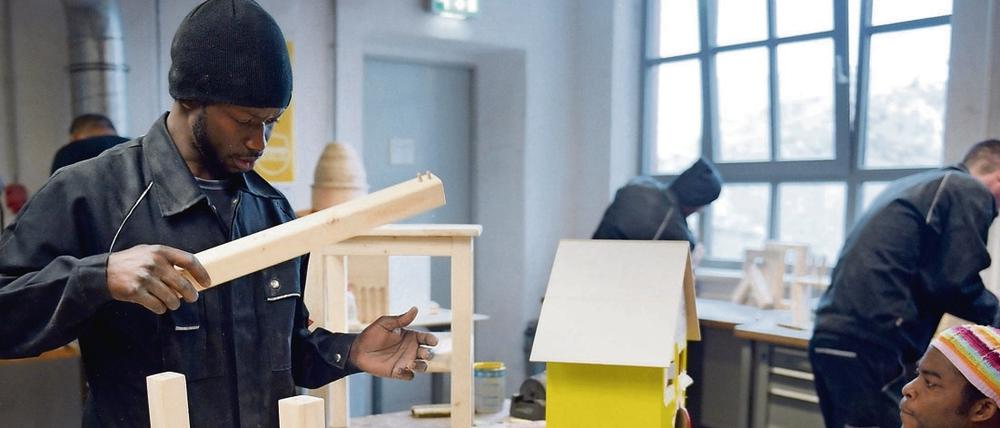 Ein junger Mann arbeitet in der Schreinerei der Flüchtlings-Initiative "Arrivo" der Handwerkskammer Berlin.