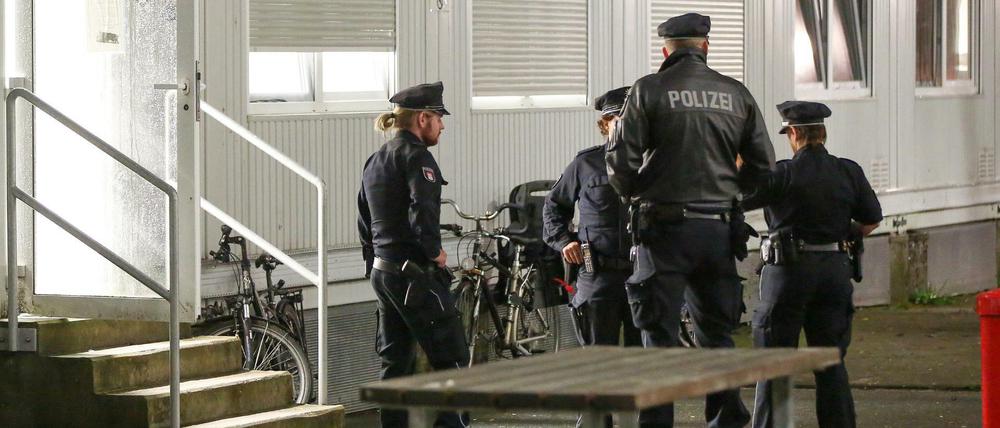 Polizisten stehen am 28.07.2017 vor Wohncontainern der Flüchtlingsunterkunft, in der der Messerstecher zuletzt wohnte.