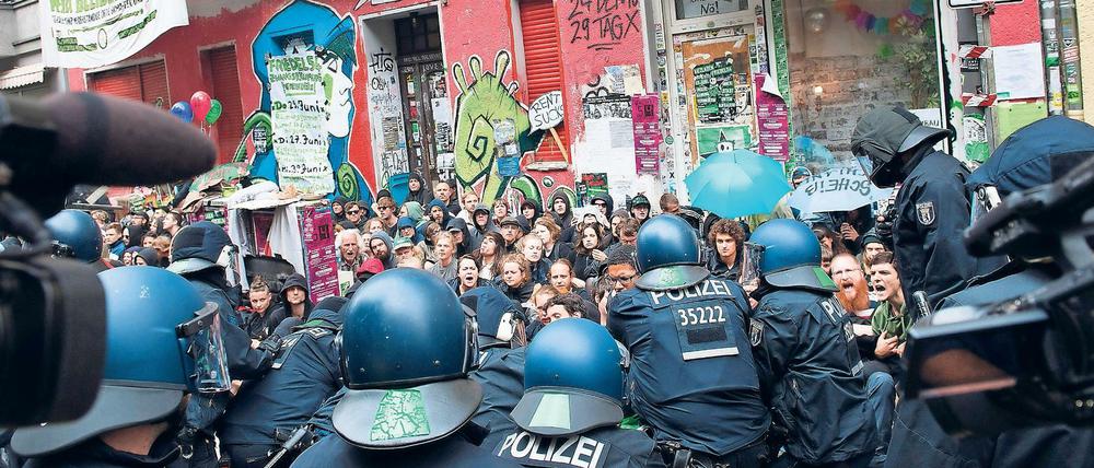 Polizisten stehen vor dem Haus Nr. 54 in der Friedelstraße in Neukölln.