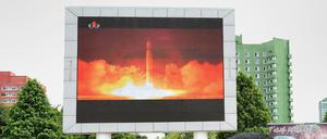 Menschen in Pjöngjang beobachten auf einer Leinwand den neueste nordkoreanische Raketentest.