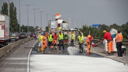 Arbeiter bei der Fahrbahnsanierung auf der Rudolf-Wissell-Brücke an der Stadtautobahn in Berlin.