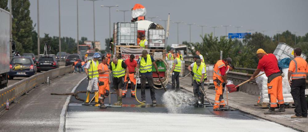 Arbeiter bei der Fahrbahnsanierung auf der Rudolf-Wissell-Brücke an der Stadtautobahn in Berlin.