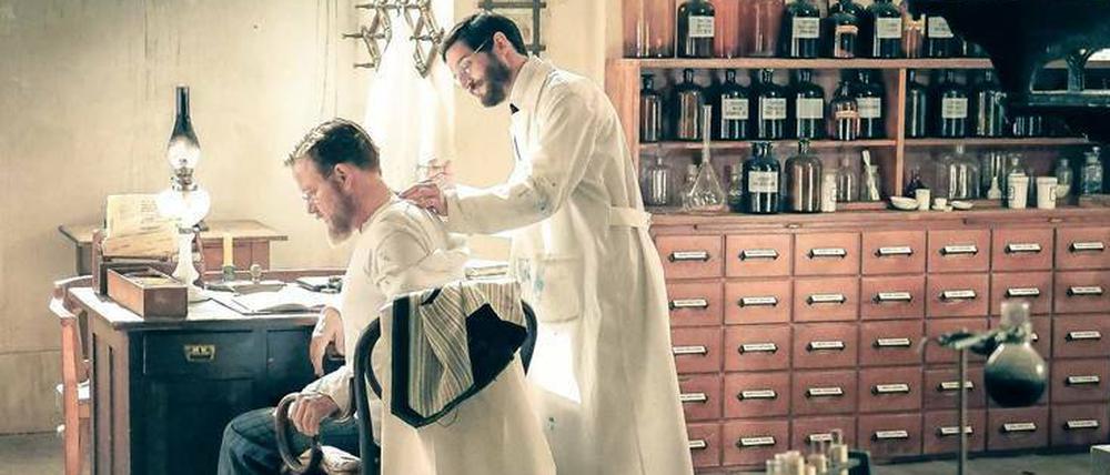 Für die Forschung brennen. In der ARD-Serie „Charité“ lässt sich Robert Koch (Justus von Dohnanyi, links) als Selbstversuch Tuberkulin von Paul Ehrlich (Christoph Bach) spritzen. Heute sorgen sich Professorinnen und Professoren um sinkende Drittmitteleinwerbungen von der Deutschen Forschungsgemeinschaft.