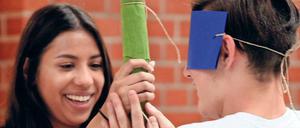 Eine Pädagogin von "Schlaufuchs Berlin" beim Piñatas-Spiel mit einem Flüchtlingsjungen im Barnim-Gymnasium. 