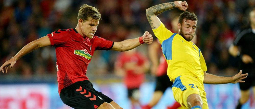 Florian Niederlechner (l) von Freiburg und Miha Blazic (r) von Domzal kämpfen um den Ball.