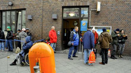 Vor der Obdachlosenhilfe am Bahnhof Zoo warten Menschen am Eingang zur Essensausgabe auf Einlass.