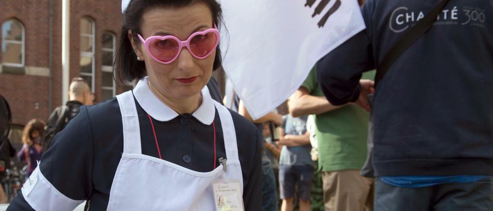 Mit Lohnkörbchen. Eine Demonstrantin in Schwesterntracht. 