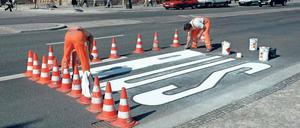 Malstunde. Für so ein Buszeichen benötigt man Männer mit starker Rückenmuskulatur, viel Farbe und noch mehr Hütchen.