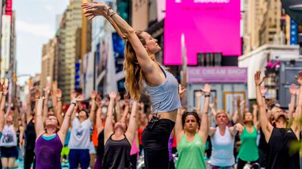 Massen-Yoga. Jedes Jahr treffen sich tausende Yoga-Fans zum Sommeranfang auf dem New Yorker Times Square.