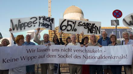 Demonstranten mit Plakaten protestieren gegen den Beschluss des Parlaments, das Einheitsdenkmal am Schloss zu errichten. Bis zur Bundestagswahl wollen sie jeden Tag gegen das geplante Denkmal demonstrieren.