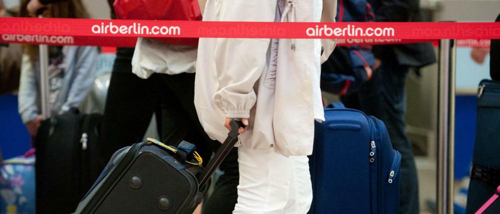 Passagiere mit ihrem Gepäck an einem Check-in-Schalter von Air Berlin im Flughafen Tegel. 